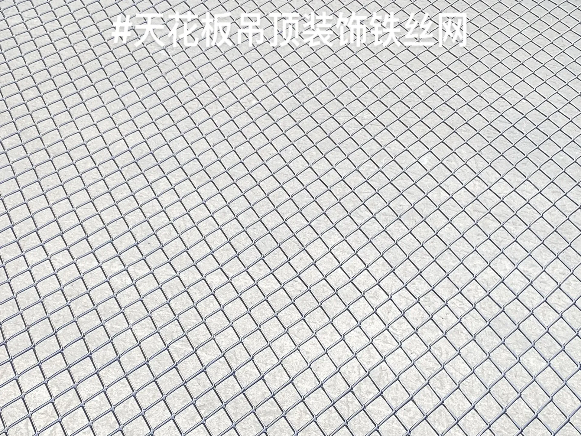 Ceiling-level view of modular metal mesh panels in an architectural interior