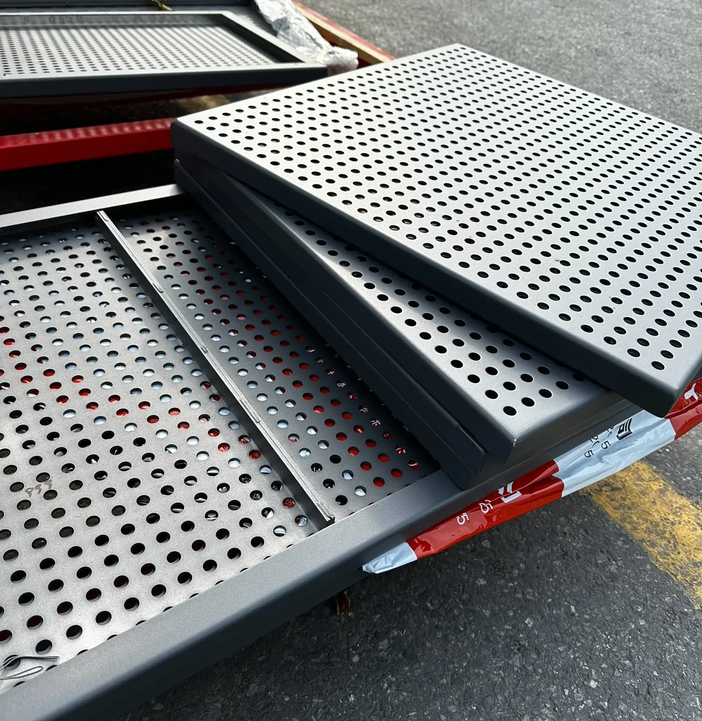 Stacked dark perforated metal panels with visible formed edges