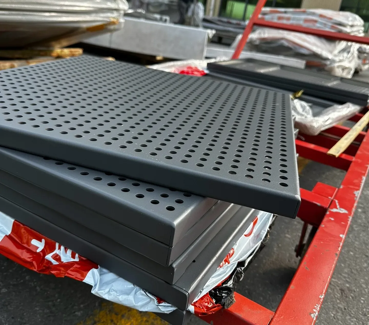 Dark perforated metal panel stack viewed from above